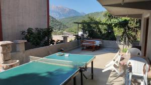 a table and chairs on a patio with mountains in the background at Apartments Nera in Utjeha