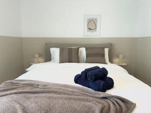 a bed with two blue towels sitting on it at Valletta and Sea Views Super Location in Il-Gżira