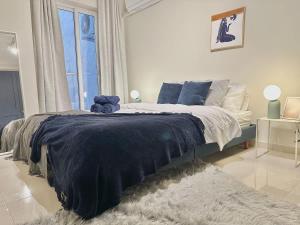 a bedroom with a large bed with a blue blanket at Valletta and Sea Views Super Location in Il-Gżira