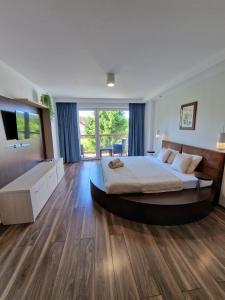a bedroom with a large bed and a large window at Willa Zacisze - Ostrowo - Komfortowe Apartamenty i Pokoje w cichej okolicy - Oaza spokoju in Ostrowo +94 photos