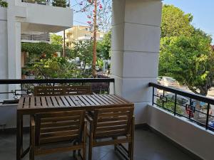 ein Holztisch und zwei Stühle auf einem Balkon in der Unterkunft S & E luxury city residences in Rhodos (Stadt)