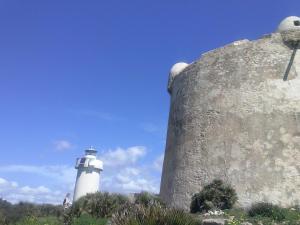 a lighthouse on a hill next to a rock at B&B La Casa Bianca di Porto Conte in Porto Conte