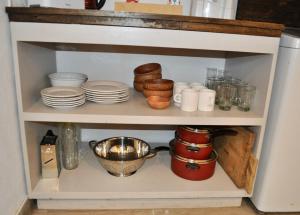 a cabinet filled with plates and bowls and dishes at Cabaña7 Loma de la Cruz in Tafí del Valle +5 photos