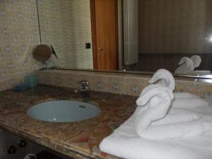 La salle de bains est pourvue de serviettes sur un comptoir avec un lavabo. dans l'établissement Da Betty, à Asti