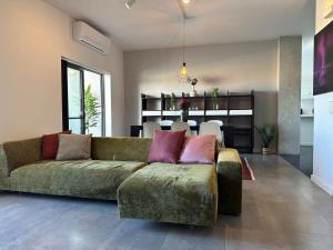 パーチャビルにある3BR Free Parking Near Sandy Beach Pacevilleのリビングルーム(緑のソファ、ダイニングルーム付)