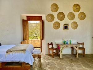 a bedroom with a bed and a table and a window at Hacienda Santa Barbara Casa Malinche in Huamantla
