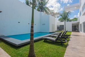 una piscina con tumbonas y una palmera en Malibu Residential 3BD Shalva, en Cozumel