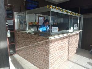 a person sitting at a counter in a restaurant at Hotel Pensión Galicia in Obaldía