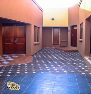 an empty room with a tile floor and two doors at EvehomeStay B&B in Soshanguve