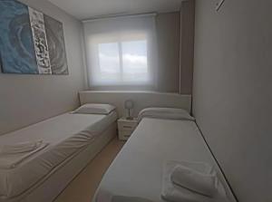 une petite chambre avec deux lits et une fenêtre dans l'établissement Costa Azahar - En Primera Línea, à El Borseral 39 autres photos