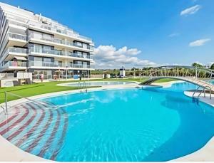 une grande piscine devant un immeuble dans l'établissement Costa Azahar - En Primera Línea, à El Borseral