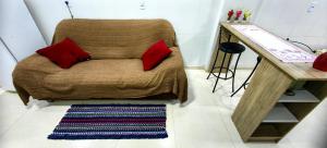 a brown chair with two red pillows and a rug at Apartamento 04 Centro de Igrejinha in Igrejinha