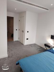 a bedroom with a blue bed in a white room at Spacious 2 bedroom flat by the Tower in London