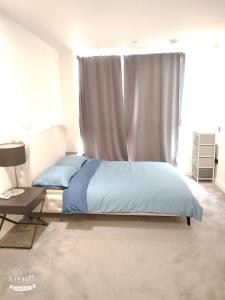 a bedroom with a bed with blue sheets and a window at Spacious 2 bedroom flat by the Tower in London