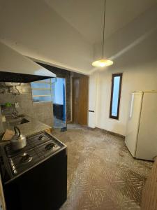 an empty kitchen with a stove and a refrigerator at Casa BUENOS AIRES in Villa María