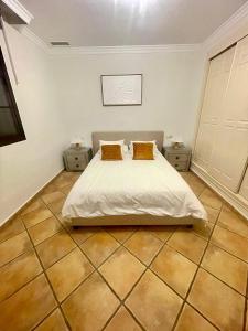 エステポナにあるElegant Suite Near Sea and Port Banusのベッドルーム1室(ベッド1台、ナイトスタンド2台付) +3枚の写真