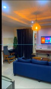 a living room with a blue couch and a tv at Spot1 in Ilado +2 photos
