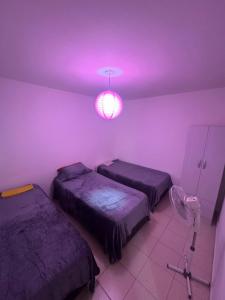 una camera con due letti e una luce viola di Alem 21 a Villa María