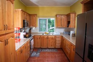 eine Küche mit Holzschränken und einem großen Fenster in der Unterkunft KoolVille in Mandeville