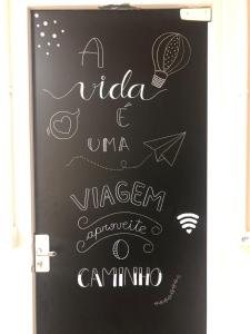 a chalkboard with a sign that says aidaumeumeumelezlezlez at Maga hospedagem in Penha