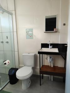 a bathroom with a toilet and a sink at Maga hospedagem in Penha