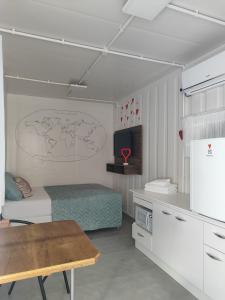 a bedroom with a bed and a tv and a table at Maga hospedagem in Penha