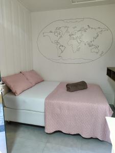 a bedroom with a bed and a world map on the wall at Maga hospedagem in Penha