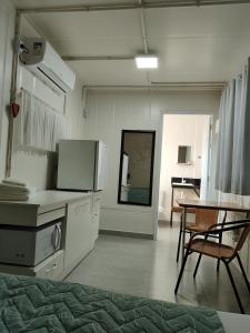 a kitchen with a counter and a table in a room at Maga hospedagem in Penha