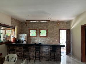 a kitchen with a bar with a brick wall at Casa Família in Brumadinho