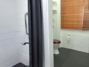 a bathroom with a toilet and a window at 2 bedrooms private bathroom 2 queen beds own entry in Long Jetty
