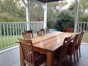 a wooden table and chairs on a deck at 2 bedrooms private bathroom 2 queen beds own entry in Long Jetty
