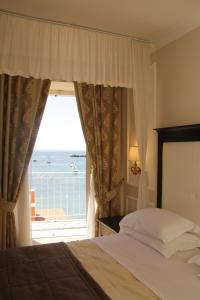 a bedroom with a bed and a view of the ocean at Hotel Miramare & Spa in Sestri Levante