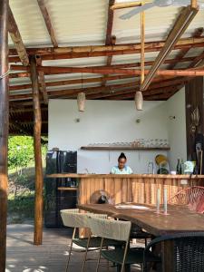 Un uomo in piedi dietro un bancone in una cucina di La Mona Eco Cabins a Palomino Altre 23 foto