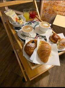 a table with croissants and cups of coffee and bread at Le Sciantose Relais in Naples