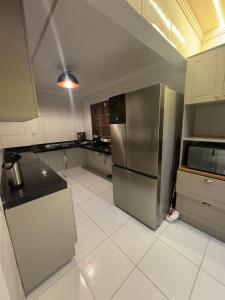 eine leere Küche mit einem Kühlschrank aus Edelstahl in der Unterkunft Moderno 3 quartos piscina e sinuca luxo in Campina Grande