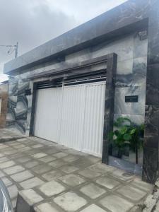 ein Gebäude mit einer weißen Garagentür drauf in der Unterkunft Moderno 3 quartos piscina e sinuca luxo in Campina Grande