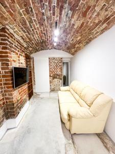 a couch in a room with a brick wall at Wagner's Refuge 2 in Rīga