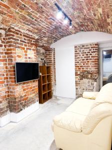 a living room with a brick wall and a couch at Wagner's Refuge 2 in Rīga +3 photos