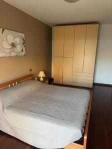 a bedroom with a large bed and a cabinet at Relax stefy apartment in Zelarino +8 photos