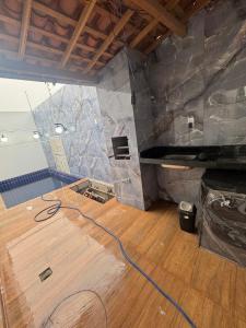 Zimmer mit einer Steinmauer und Holzböden in der Unterkunft Moderno 3 quartos piscina e sinuca luxo in Campina Grande