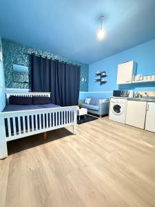 a blue room with a crib and a kitchen at The Aqua Stay in city centre in Chesterton