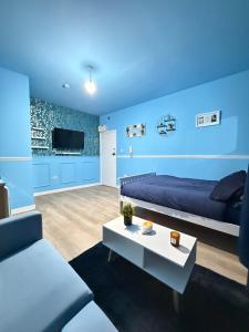 a blue room with a bed and a couch and a table at The Aqua Stay in city centre in Chesterton