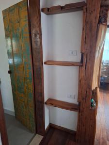 een kast met houten planken naast een deur bij Chalé Cores da Mata Inaugurado recente - novinho in Carrancas