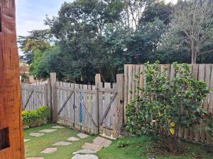 een houten hek met een boom ervoor bij Chalé Cores da Mata Inaugurado recente - novinho in Carrancas