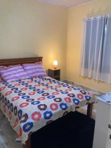 a bedroom with a bed with a quilt on it at Brisa Do mar Apartamento 2 in Cabo Frio