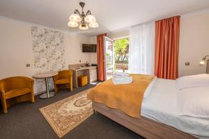 a hotel room with a bed and a table and chairs at O. W. Jodełka in Łeba