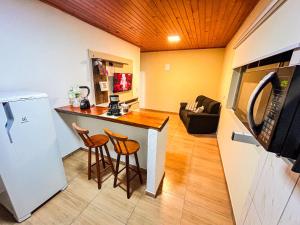 a kitchen with two bar stools and a refrigerator at Hospedaria MonteNegro in Campos do Jordão +15 photos