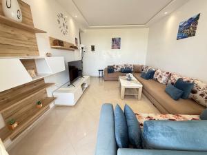 a living room with a couch and a tv at Bahia plage in Tétouan