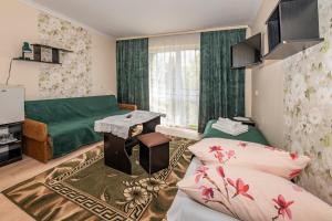 a living room with a green couch and a table at O. W. Jodełka in Łeba