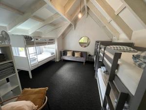 Dormitorio con letti a castello e divano di Big family holiday in Paihia a Paihia